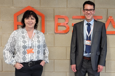 Linda Smith, CEO of BetaDen and Vincent Borgraeve, Co-founder of FloWide standing in front BetaDen's logo in Malvern Hills Science Park