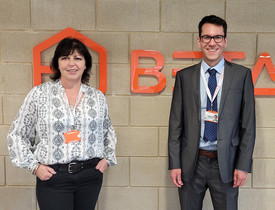 Linda Smith, CEO of BetaDen and Vincent Borgraeve, Co-founder of FloWide standing in front BetaDen's logo in Malvern Hills Science Park